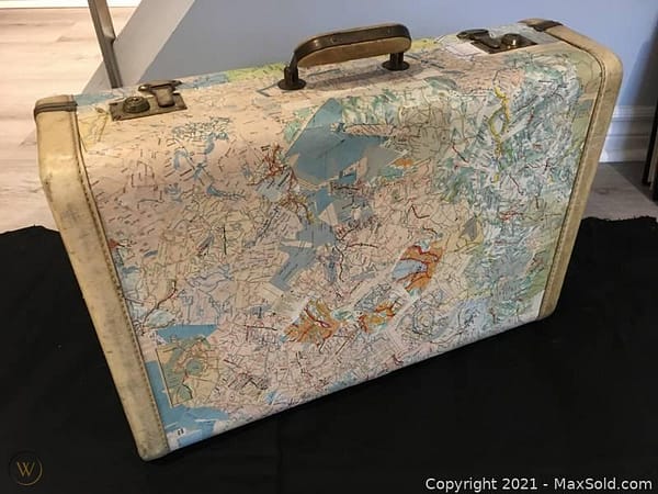 A vintage suitcase featuring a decoupaged roadmap 