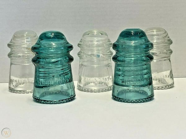 Five clear and aqua glass insulators by the Hemingray Glass Company